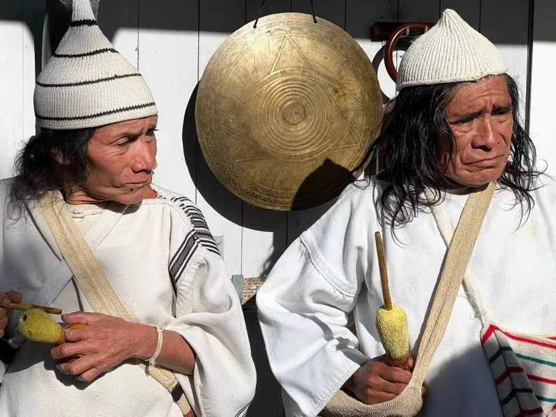 Two Kogi elders in traditional white dress at a gathering